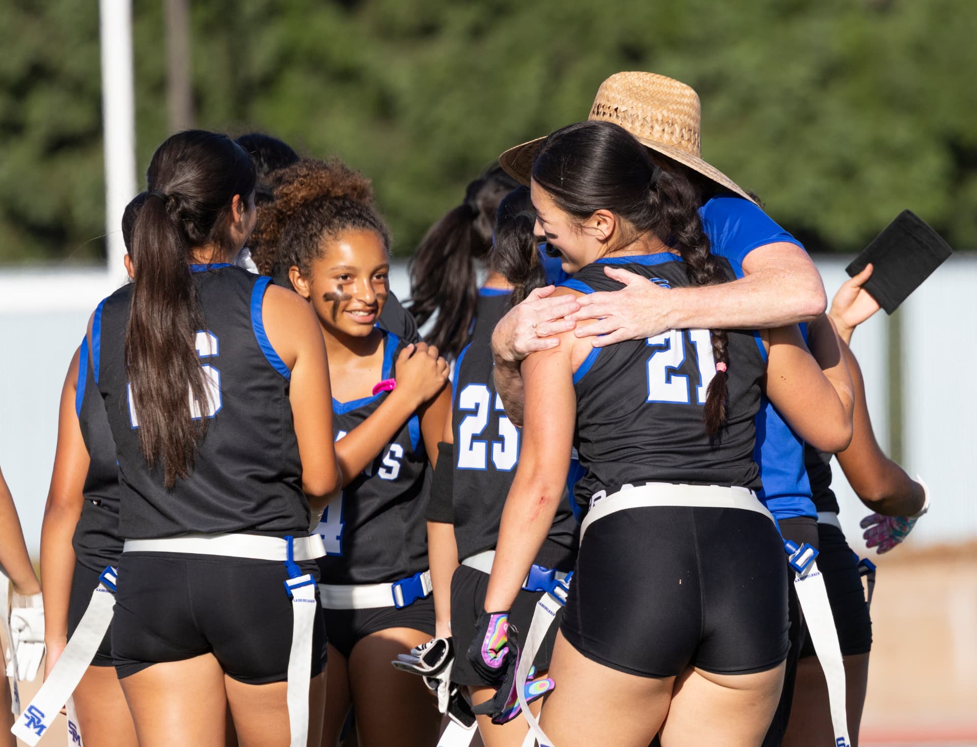 The Titans huddle up as the coach hugs captain Keilani Kooper, No. 21, after a game.
