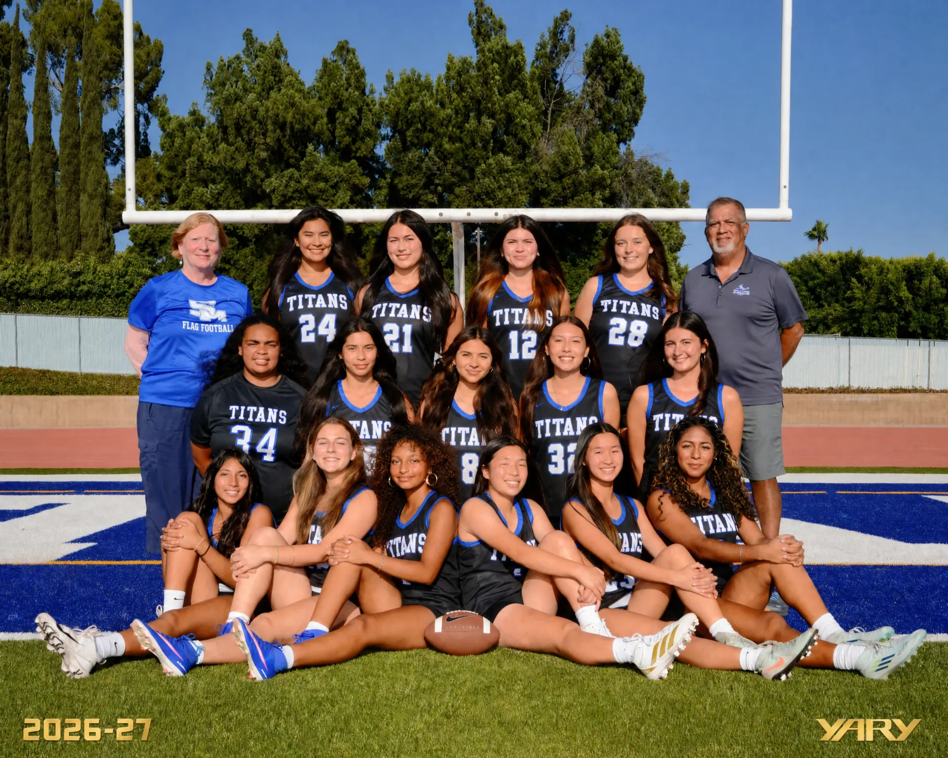 The 2026-27 San Marino Titans girls flag football team and coaching staff posing under the goalposts on the field.